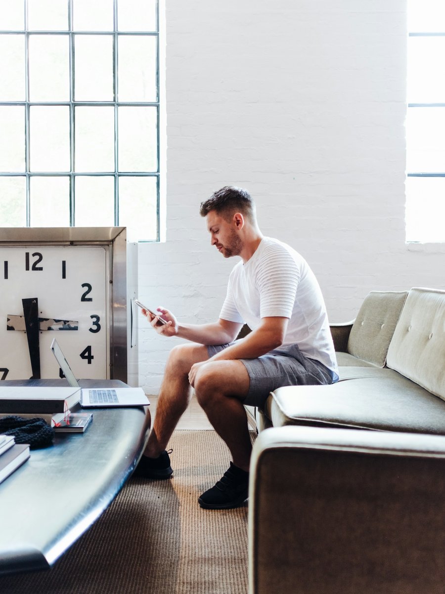 A man relaxing in a bright room with his phone