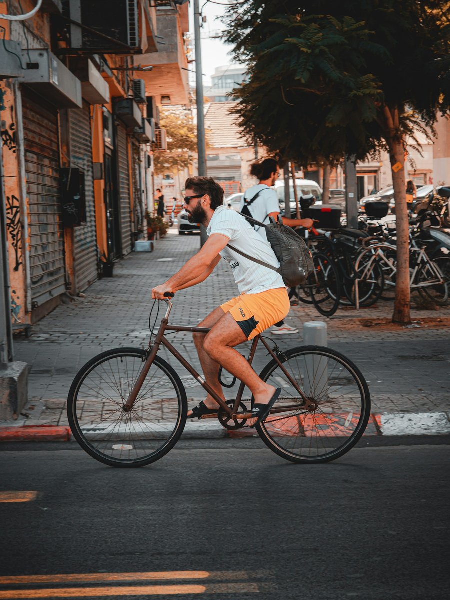 A cyclist on a red bike on a city street