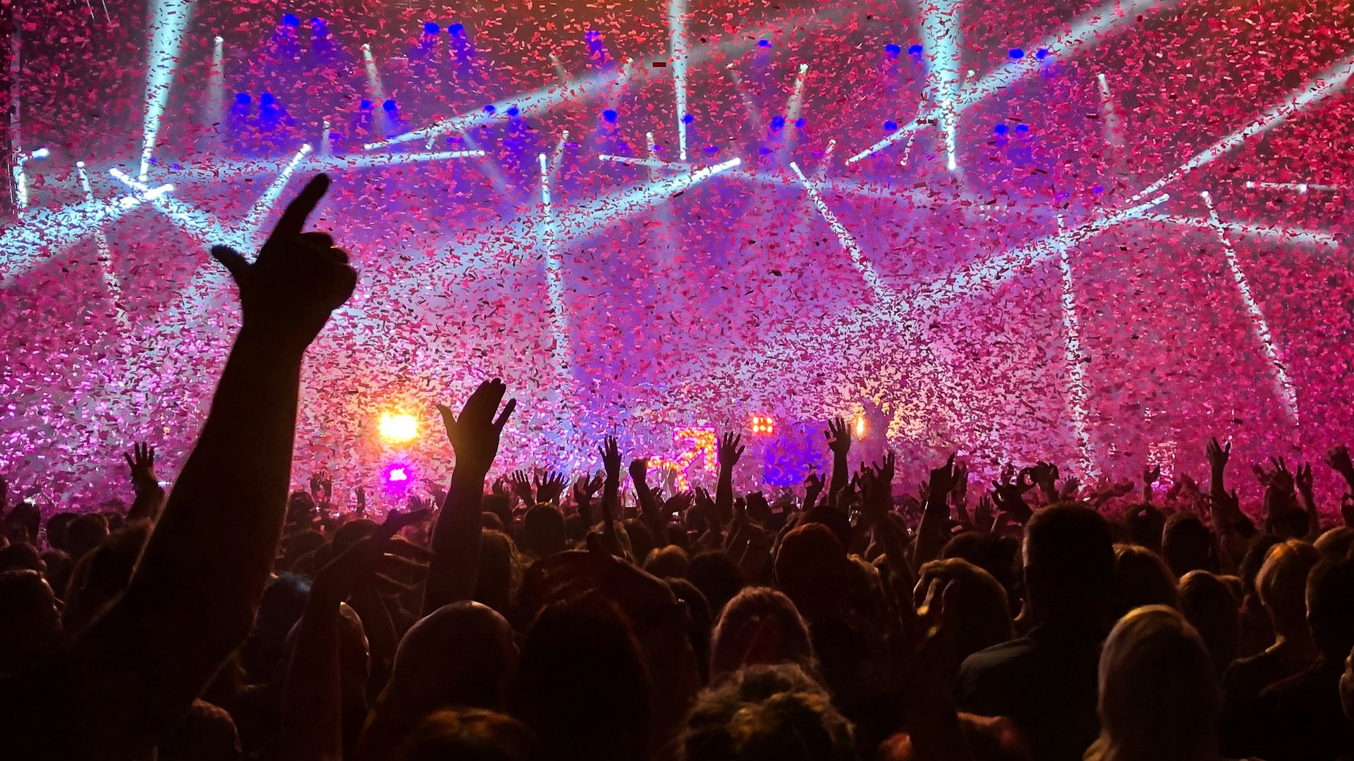 Hands up at a concert as confetti falls