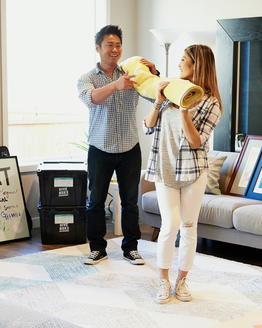 A couple unpacking in their new home, boxes beside them